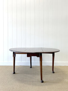An Antique Mahogany Drop Leaf Dining Table with Pad Feet
