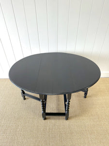 An Antique English Ebonized Country Oak Drop Leaf Gate Leg Table