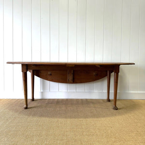 An Antique Irish Pine Oval Drop Leaf Kitchen Dining Table with Spoon Feet