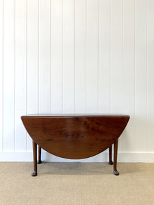 An Antique Mahogany Drop Leaf Dining Table with Pad Feet