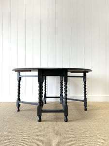 An Antique English Ebonized Country Oak Drop Leaf Gate Leg Table