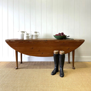 An Antique Irish Pine Oval Drop Leaf Kitchen Dining Table with Spoon Feet