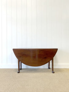 An Antique Mahogany Drop Leaf Dining Table with Pad Feet